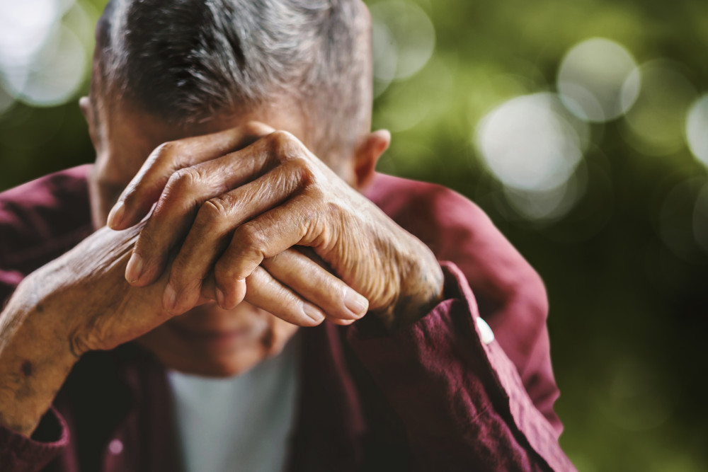 a close-up of a person with their hands covering their face